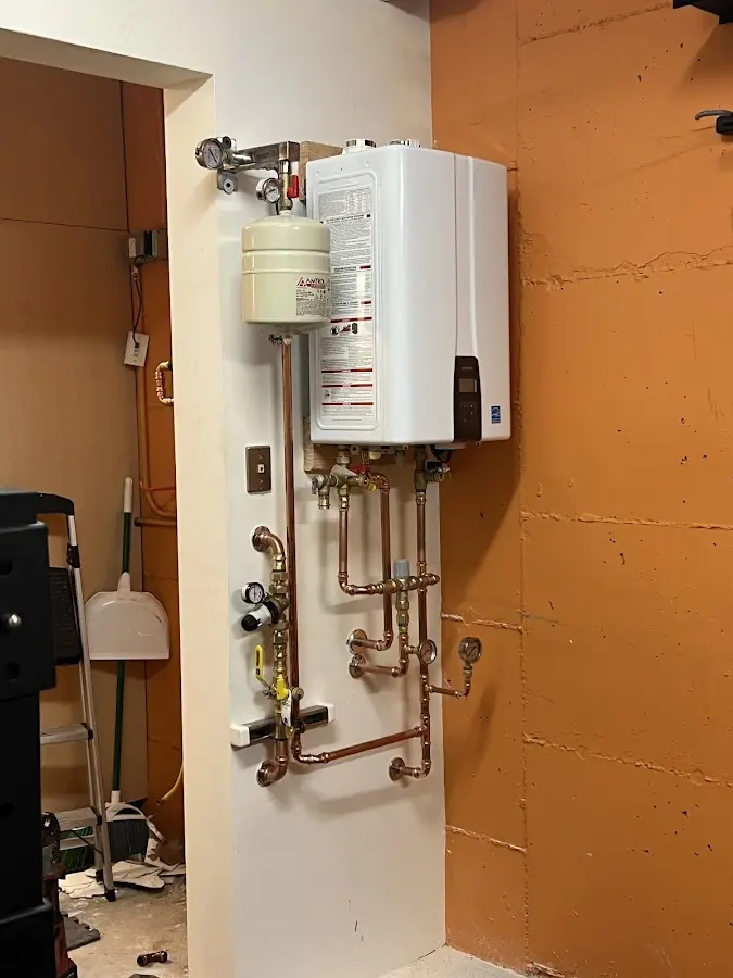 Plumbing technician inspecting water heater connections in Charles Town